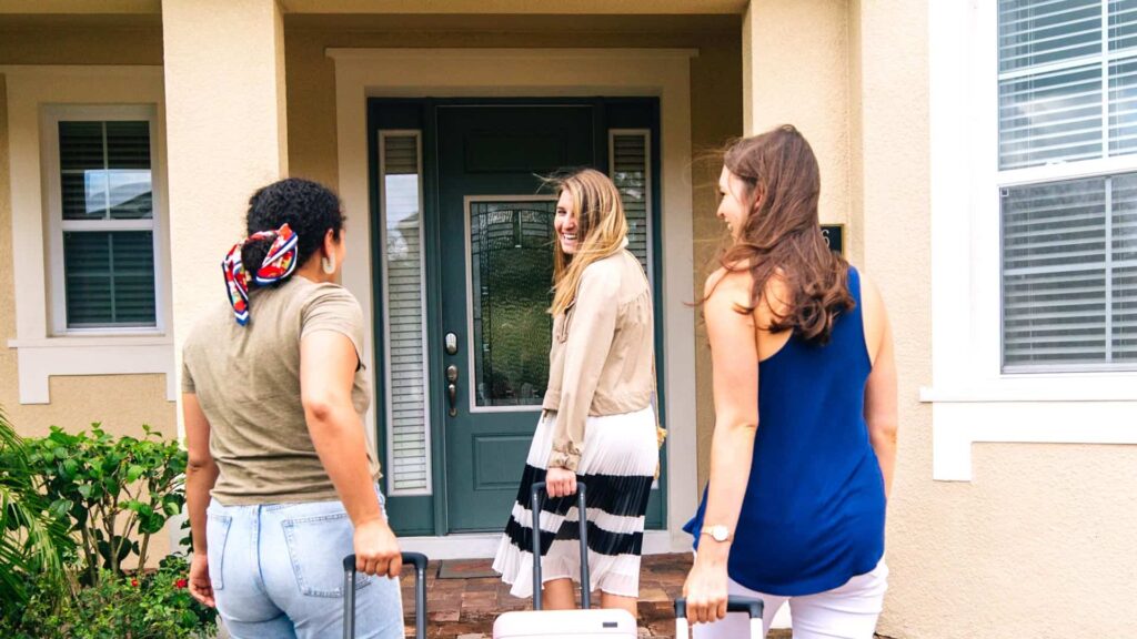 Women with rolling travel luggage arrive at a vacation home at Encore Resort in Orlando, Florida